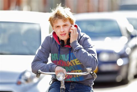 Een jongen belt tijdens het fietsen. FOTO Archief RijschoolPro