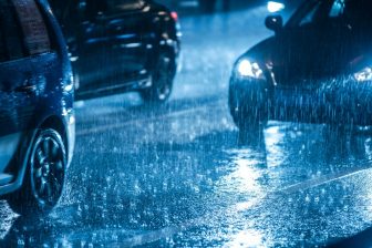 Auto rijdt 's nachts door de regen BEELD iStock