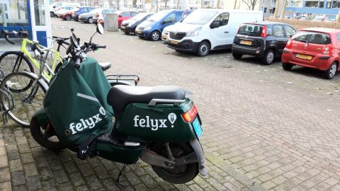 Felyx scooter voor fietsen en geparkeerde auto's