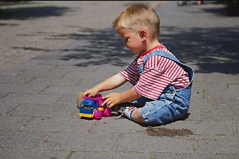 Kind speelt op straat