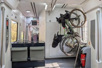 Fietshaken boven klapstoelen bieden plek aan meer fietsen zoals in Spaanse treinen.