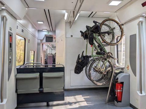 Fietshaken boven klapstoelen bieden plek aan meer fietsen zoals in Spaanse treinen.