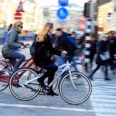 Foto: twee fietsers zoeven door Amsterdam