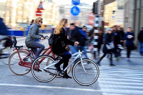 Foto: twee fietsers zoeven door Amsterdam