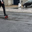 Een man rijdt op een elektrisch skateboard