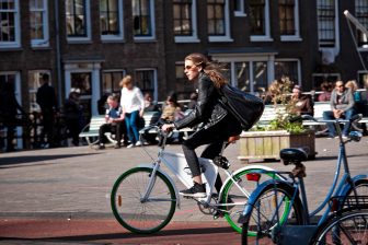 Beeld: vrouw op fiets in Amsterdam