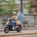 Beeld: vrouw op scooter in Amsterdam